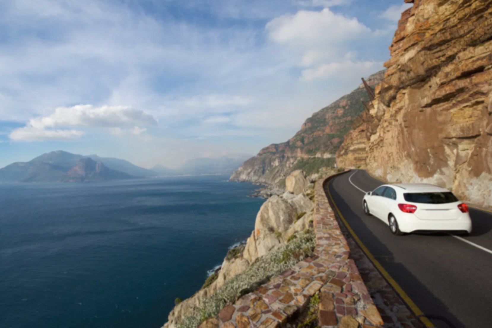 Vehículo circulando por la ruta costera de Chapmans Peak, Sudáfrica