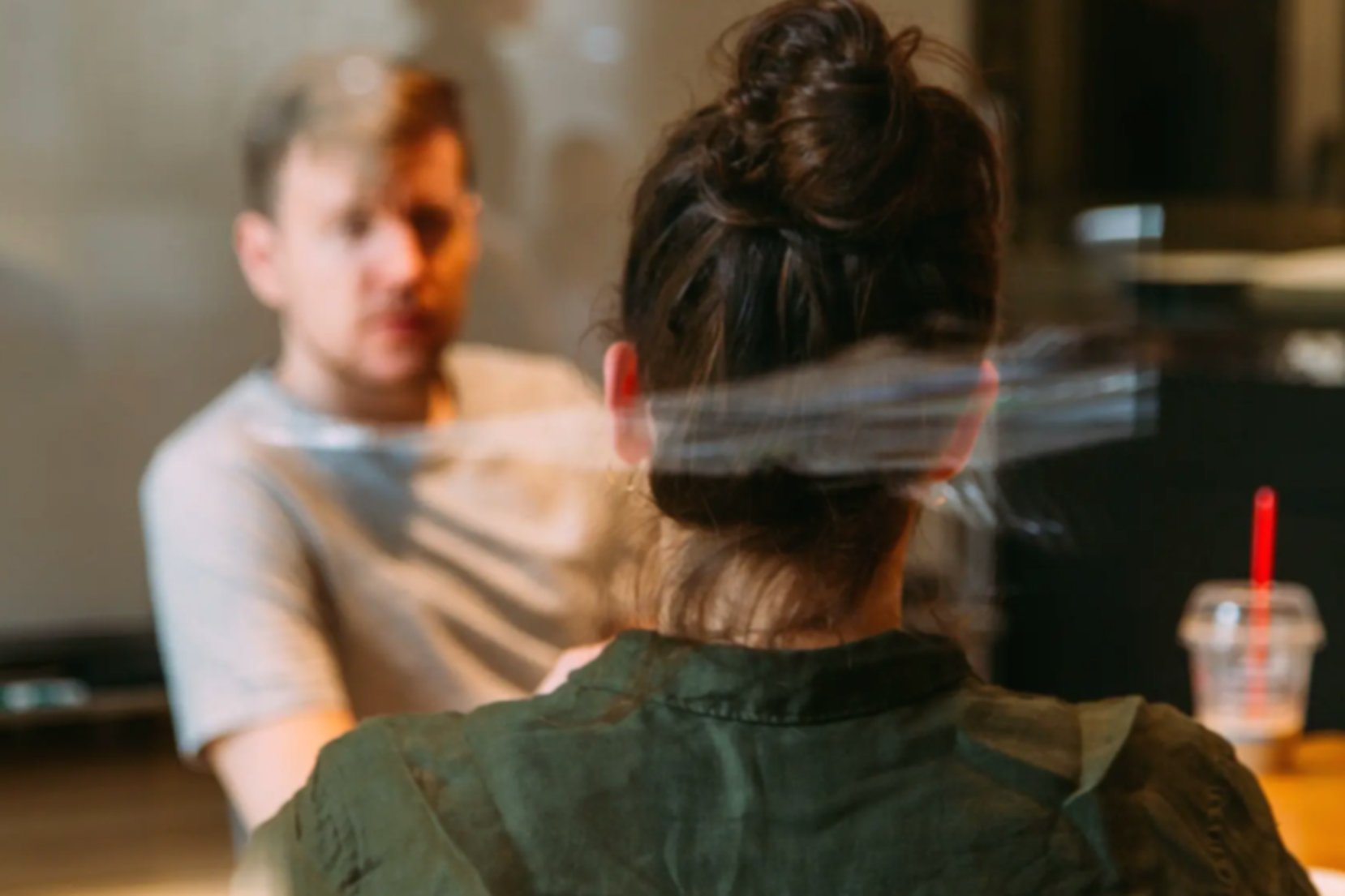a man and a woman having taking part in a job interview, sitting across from each other at a desk
