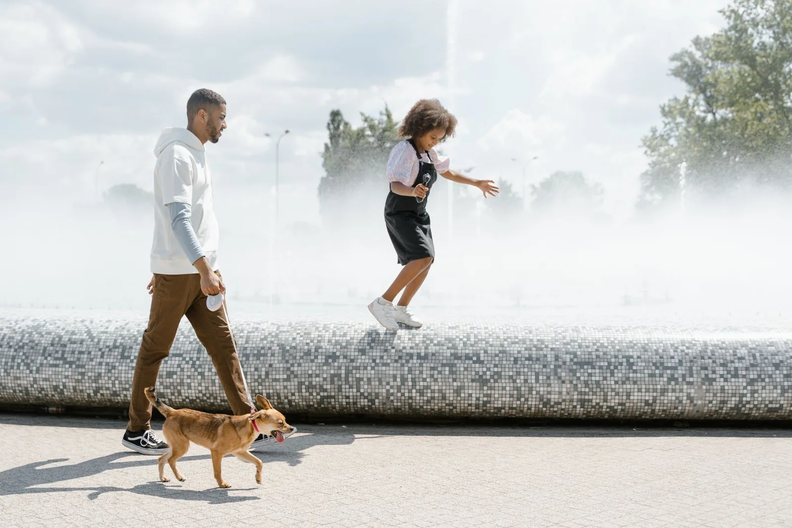Familia paseando a su perro en un parque