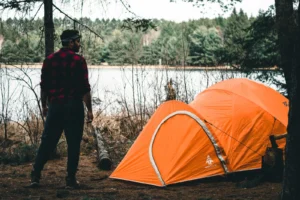 Carpa de camping al borde de un lago al atardecer