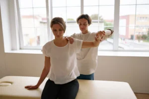 Terapeuta realizando ejercicios con paciente en consulta de fisioterapia