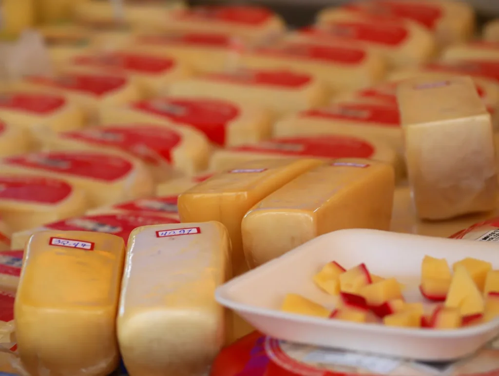 Puesto de queso tradicional con ruedas y mesas en un mercado
