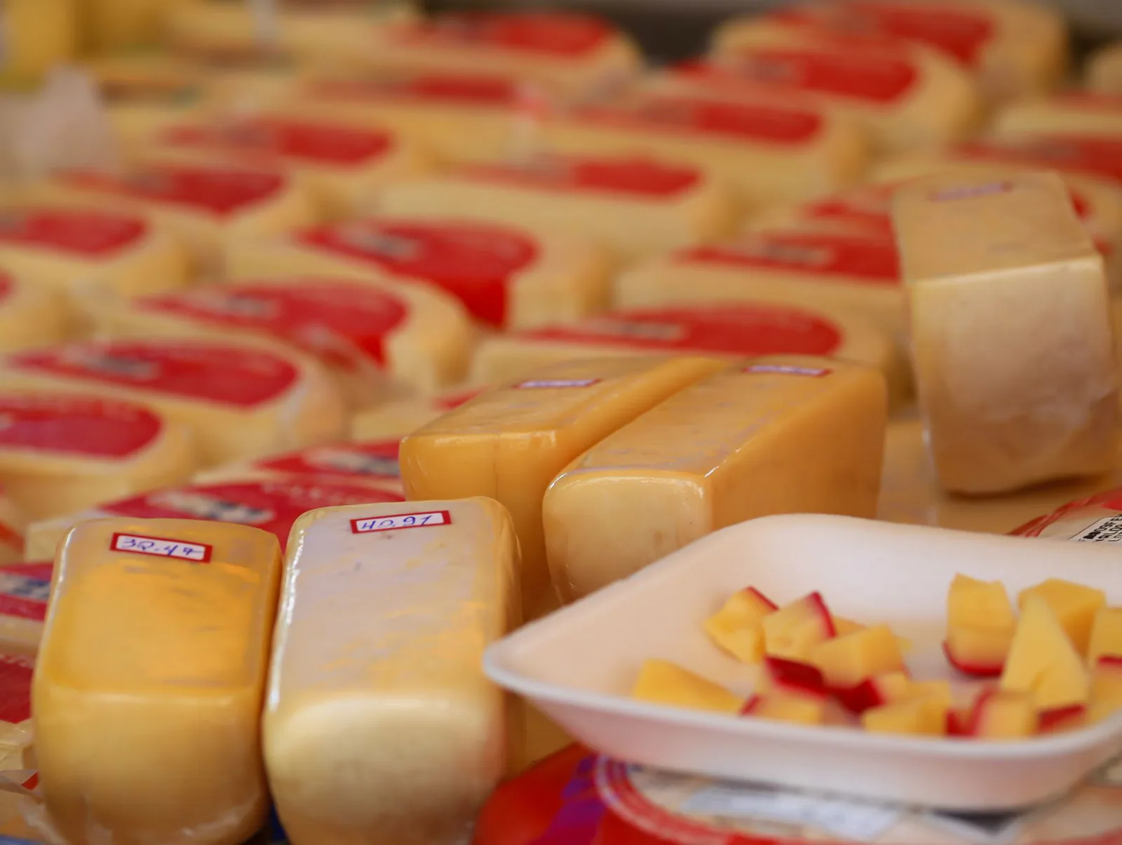 Puesto de queso tradicional con ruedas y mesas en un mercado
