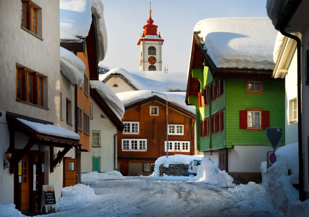 Paisaje alpino con casas bajo nieve en invierno