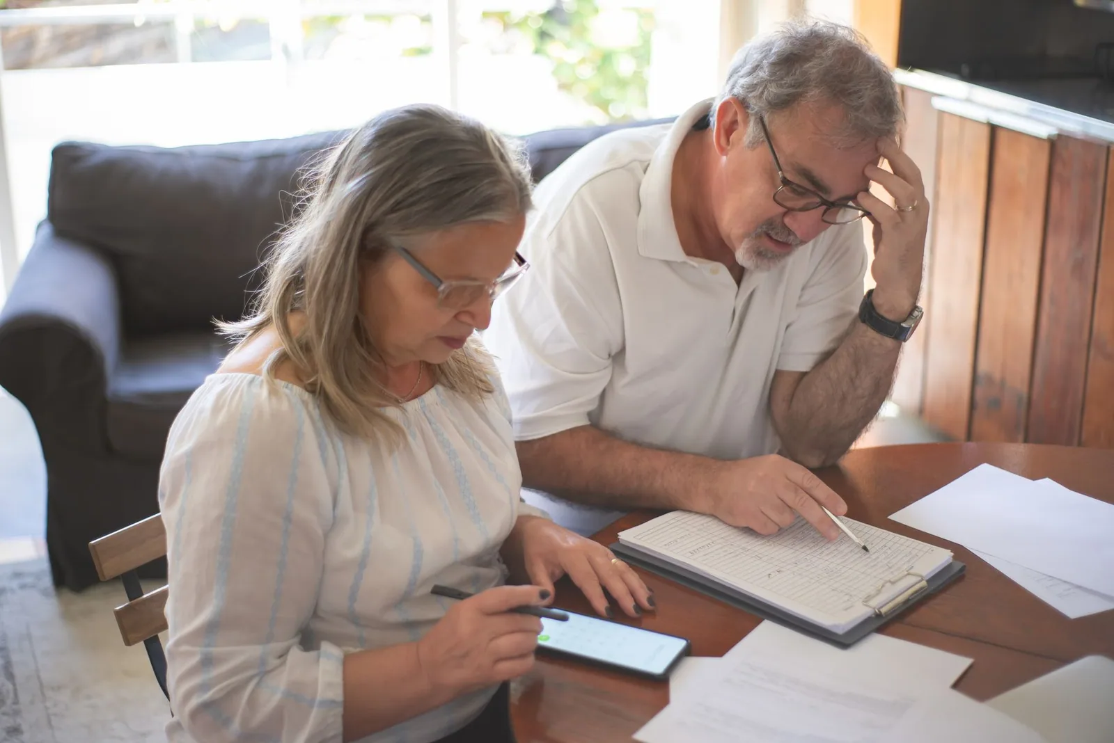 Pareja mayor revisando documentos de pensión