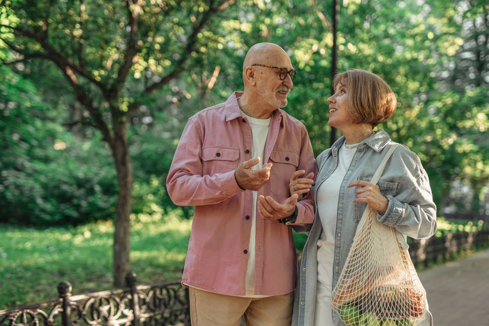 Pareja de jubilados caminando en un parque alpino