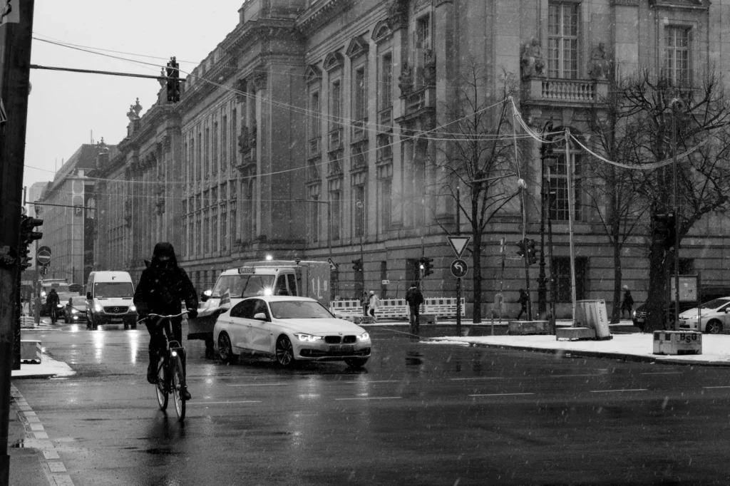 Ciclista cruzando una calle nevada en los Países Bajos