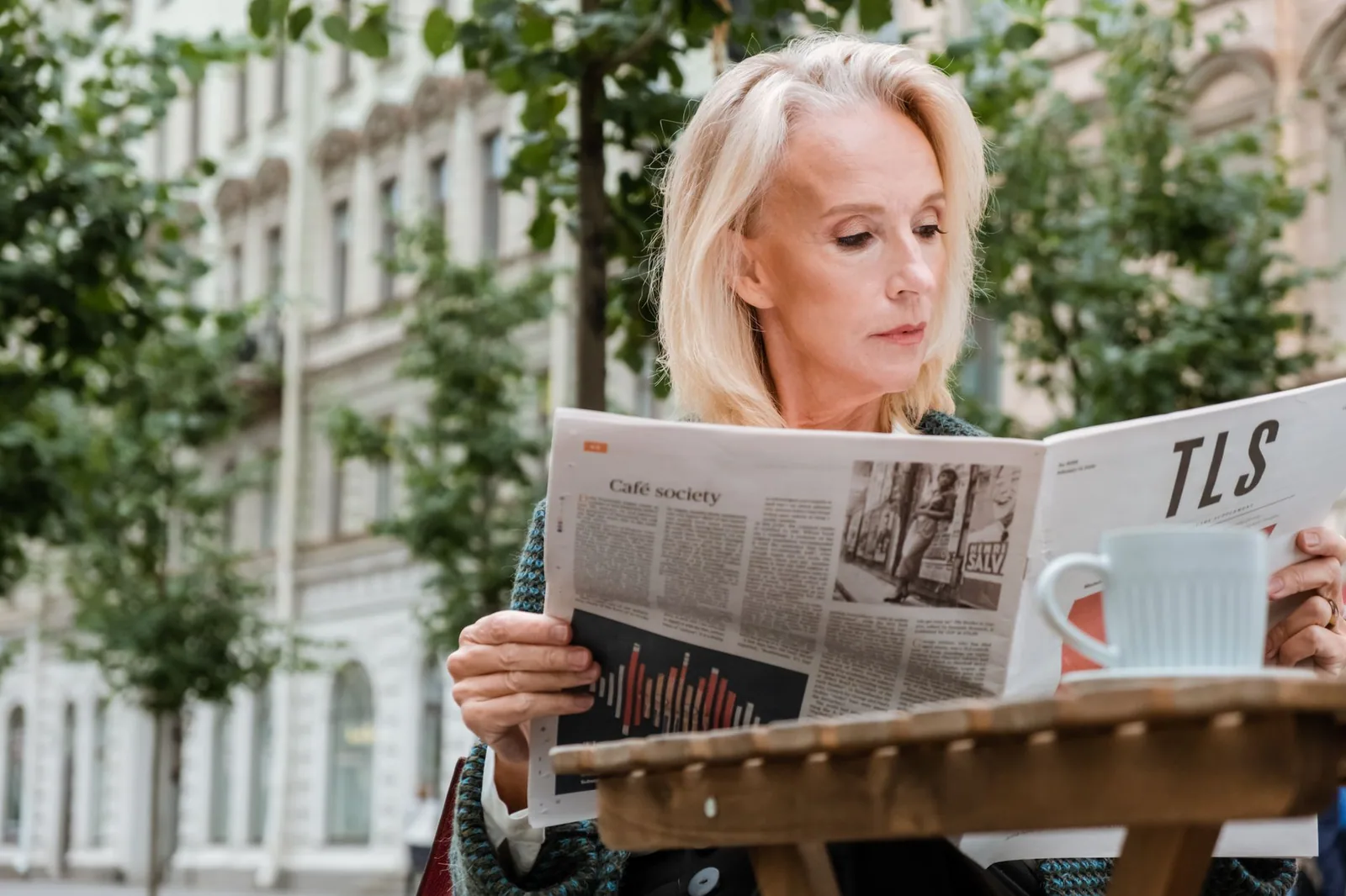 Persona leyendo periódico en una cafetería