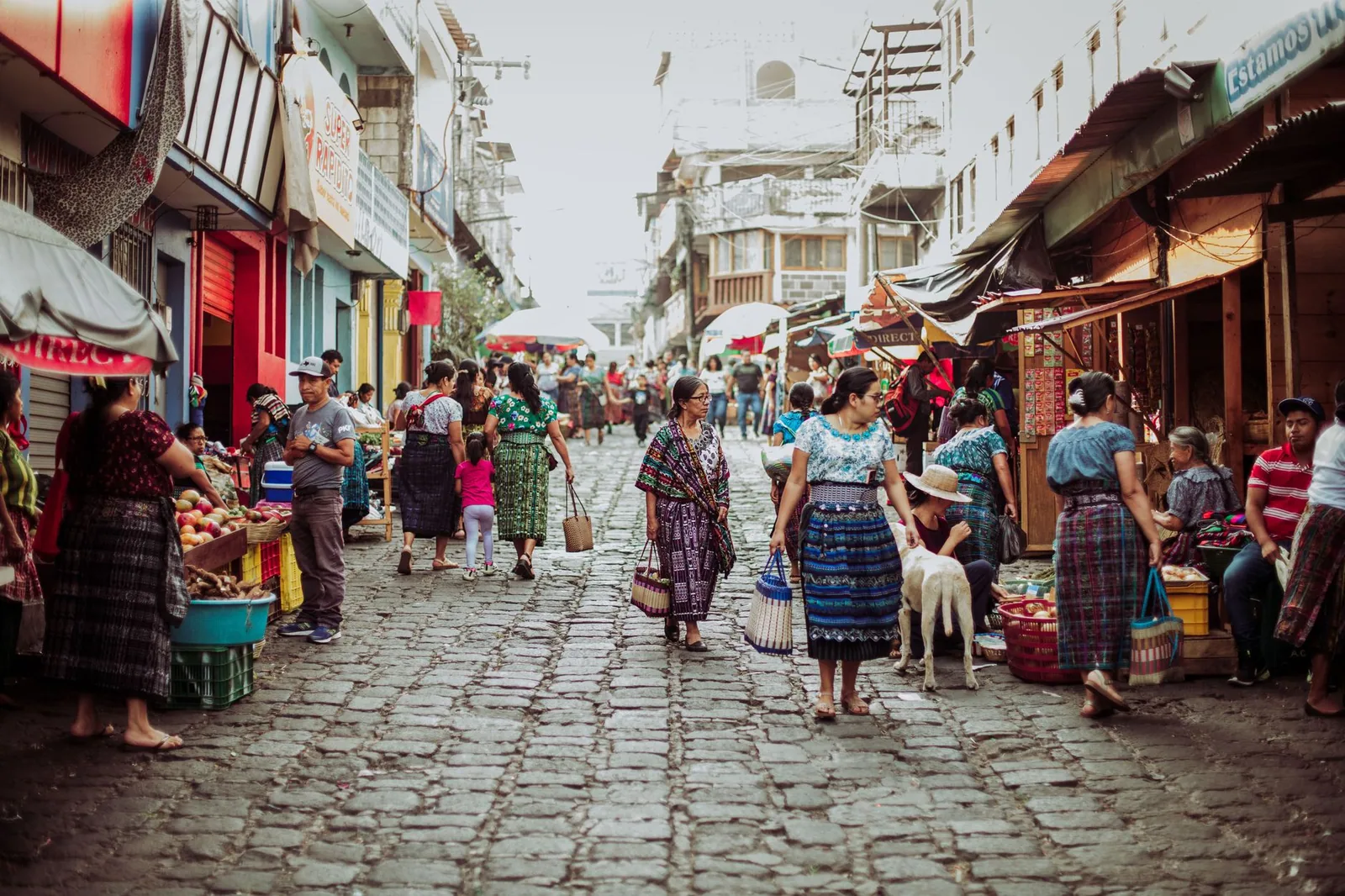 Mercado tradicional en una calle empedrada con puestos coloridos