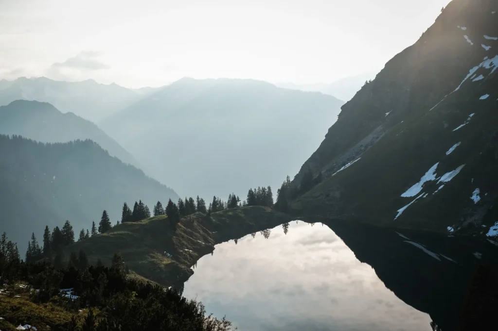 Lago alpino con montañas nevadas al amanecer