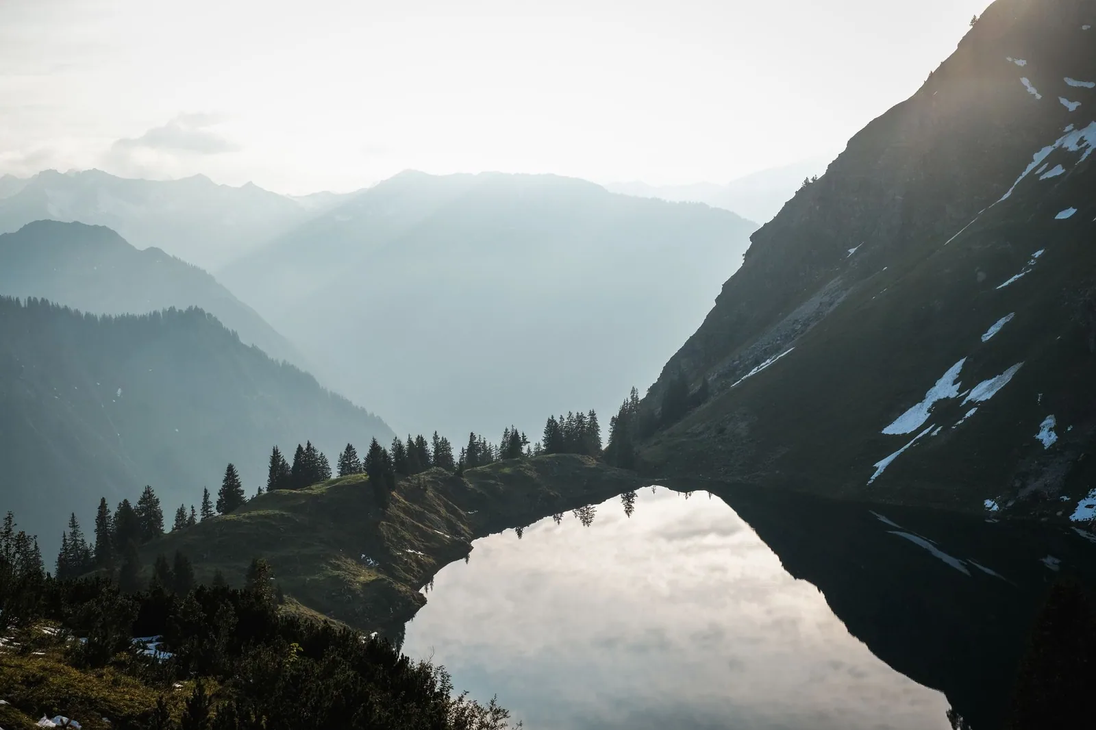 Lago alpino con montañas nevadas al amanecer