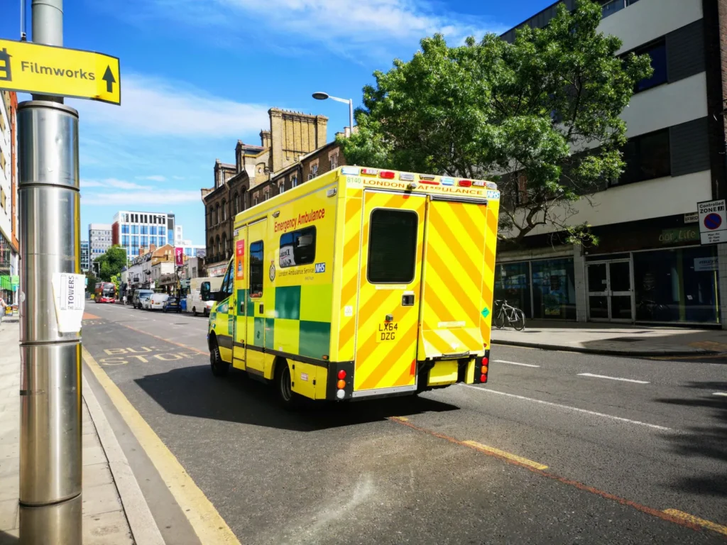 Ambulancia roja atendiendo a una persona en la calle
