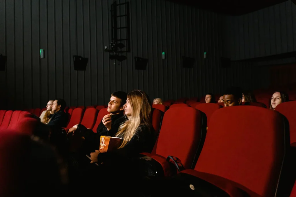 Escena de una sala de cine con pantalla y espectadores