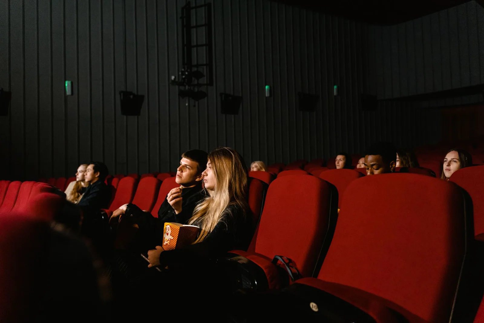 Escena de una sala de cine con pantalla y espectadores