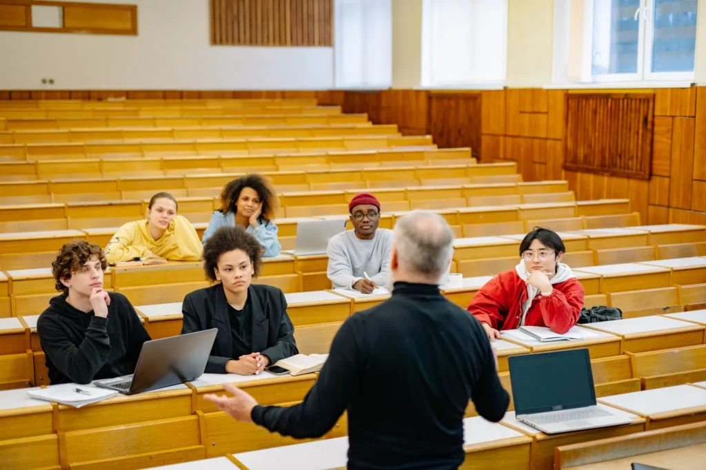 Aula universitaria con estudiantes revisando documentos