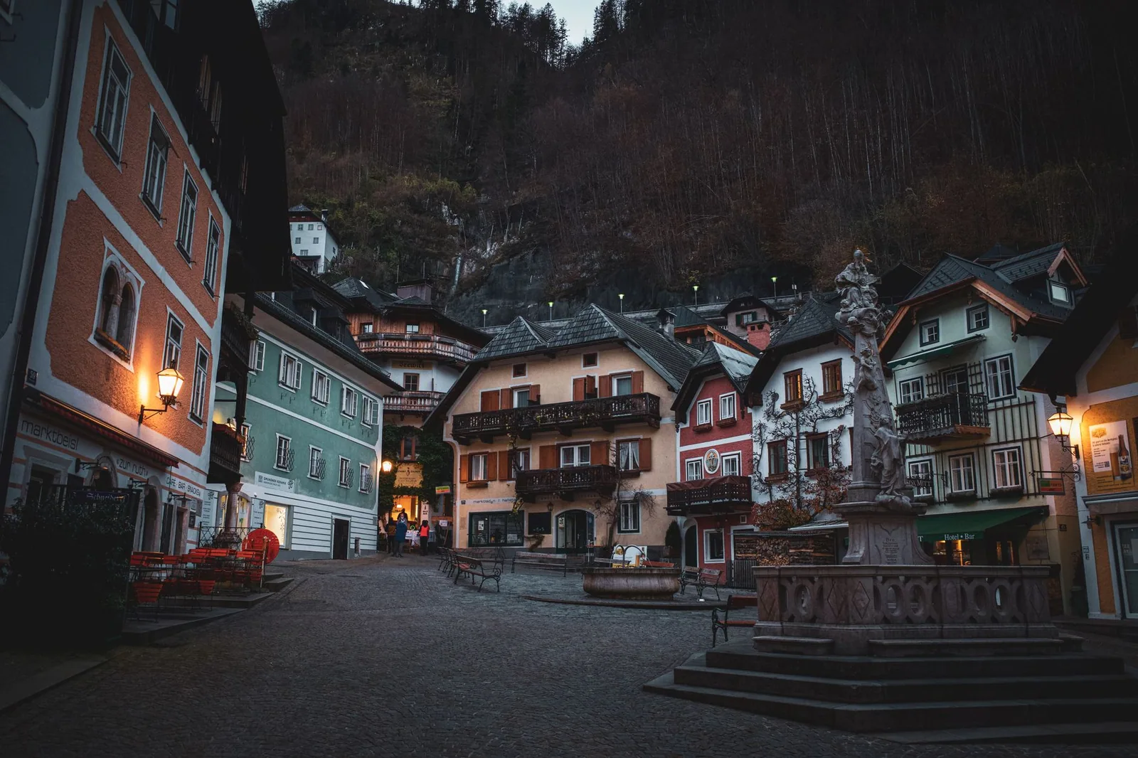 Plaza de un pueblo alpino con edificios tradicionales y cielo azul