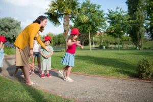 Au pair joven jugando con los niños en el jardín