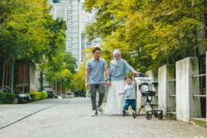 Familia paseando con cochecito de bebé por un parque