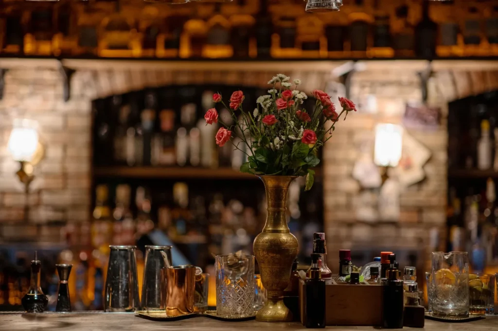 Interior de bar con luces tenues y copas sobre la mesa