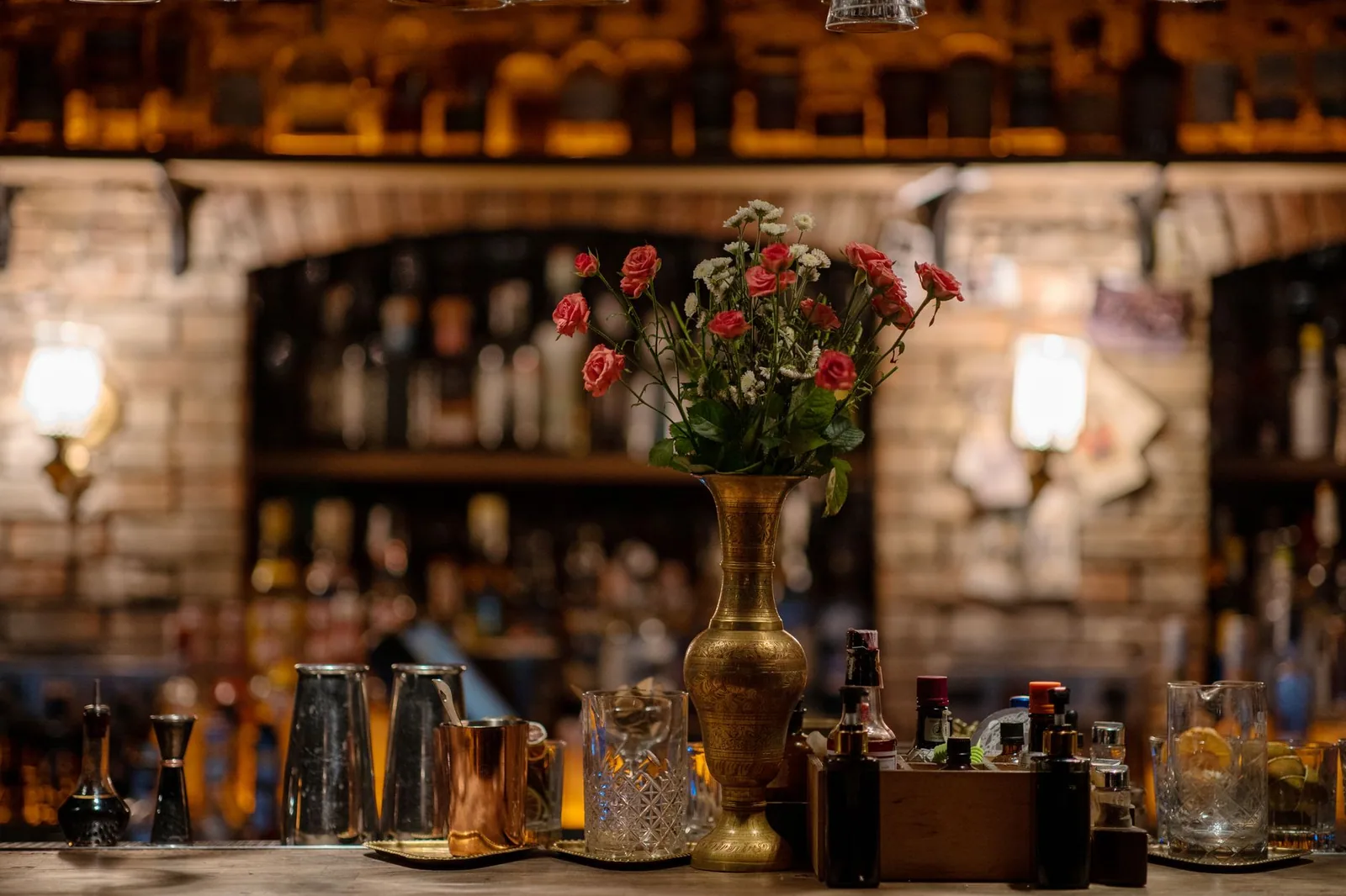 Interior de bar con luces tenues y copas sobre la mesa