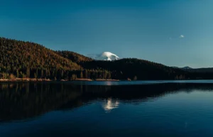 Lago de montaña con picos nevados y cielo azul en Suiza