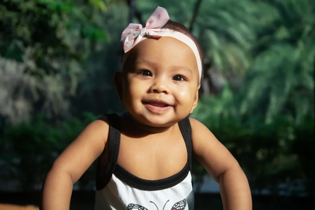 Bebé sonriendo en un parque al aire libre